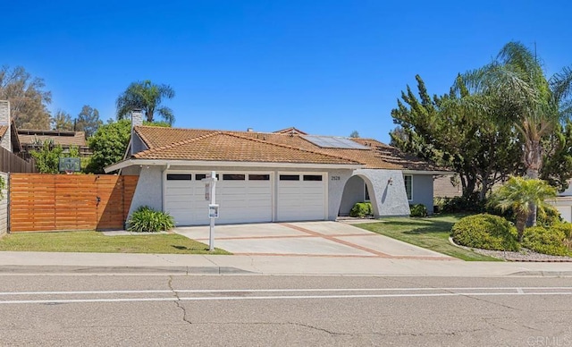 2528 Windmill View Rd, El Cajon, CA 92020 - ranch-style home featuring an attached garage, stucco siding, a tiled roof, concrete driveway, and roof mounted solar panels
