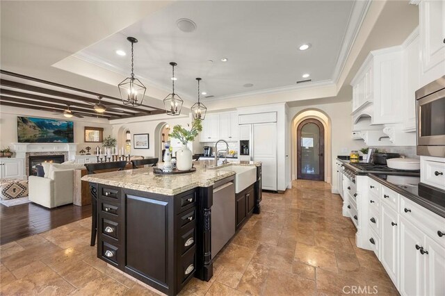 21925 Heatheridge Dr, Yorba Linda, CA 92887 - kitchen featuring arched walkways, a raised ceiling, white cabinets, crown molding, and a sink