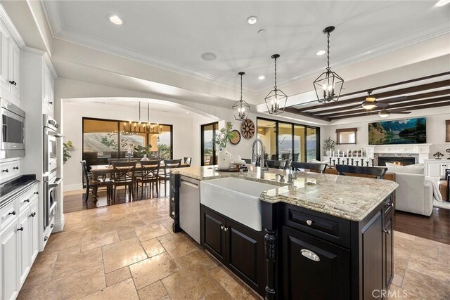 21925 Heatheridge Dr, Yorba Linda, CA 92887 - kitchen with a sink, a chandelier, dark cabinetry, stone tile flooring, and white cabinets