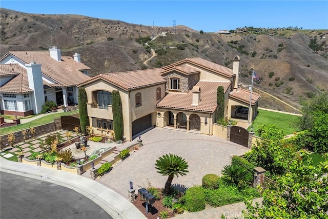 21925 Heatheridge Dr, Yorba Linda, CA 92887 - mediterranean / spanish home featuring a gate, a tile roof, stucco siding, driveway, and a chimney
