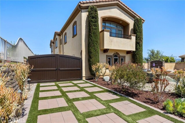 21925 Heatheridge Dr, Yorba Linda, CA 92887 - mediterranean / spanish house with a balcony, stucco siding, a gate, and a tile roof