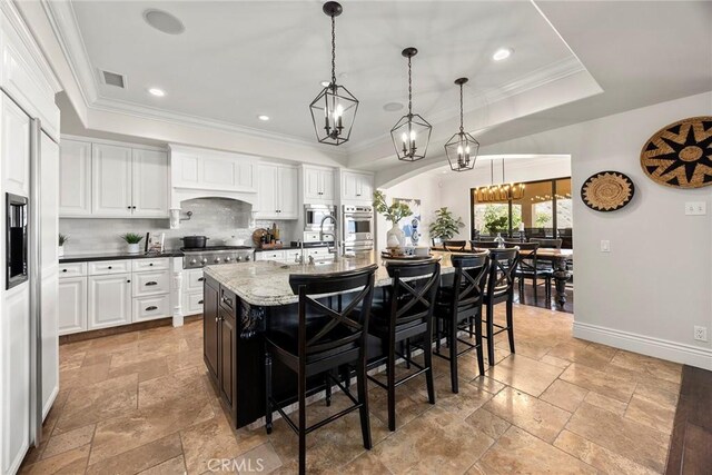 21925 Heatheridge Dr, Yorba Linda, CA 92887 - kitchen with a raised ceiling, stone tile floors, a chandelier, backsplash, and ornamental molding