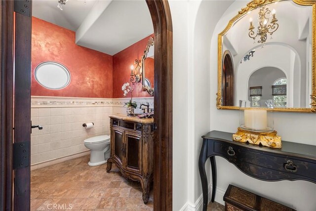 21925 Heatheridge Dr, Yorba Linda, CA 92887 - bathroom featuring tile walls, toilet, a wainscoted wall, vanity, and stone finish flooring