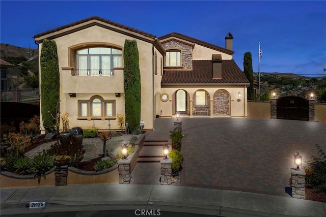 21925 Heatheridge Dr, Yorba Linda, CA 92887 - mediterranean / spanish-style house featuring stucco siding, decorative driveway, a gate, a tile roof, and a chimney