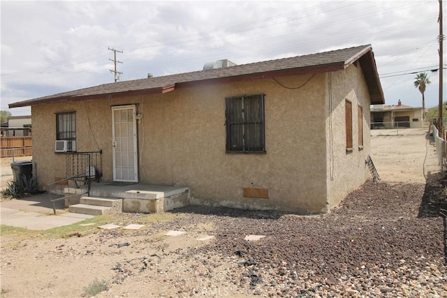 120 W Williams St, Barstow, CA 92311 - rear view of house with stucco siding, roof with shingles, crawl space, and cooling unit