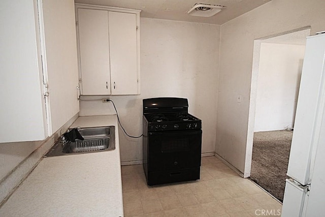 120 W Williams St, Barstow, CA 92311 - kitchen featuring gas stove, freestanding refrigerator, a sink, white cabinets, and light countertops