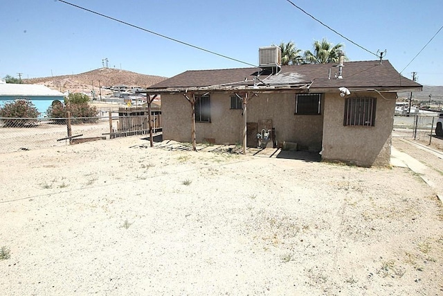 120 W Williams St, Barstow, CA 92311 - back of property with stucco siding, central AC, and a shingled roof