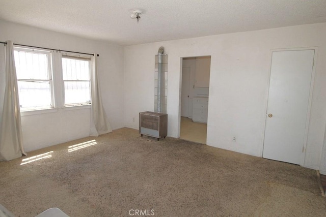 120 W Williams St, Barstow, CA 92311 - unfurnished bedroom with carpet flooring, a textured ceiling, and heating unit