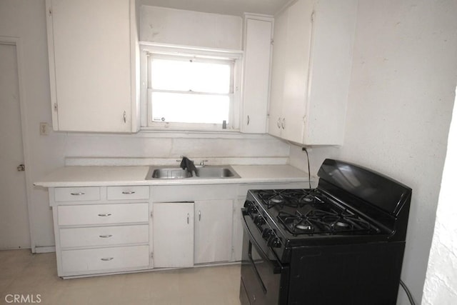 120 W Williams St, Barstow, CA 92311 - kitchen featuring gas stove, a sink, light countertops, and white cabinets