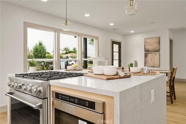 5161 E 27th St, Long Beach, CA 90815 - kitchen with high end stainless steel range oven, light wood-style flooring, recessed lighting, light stone countertops, and pendant lighting