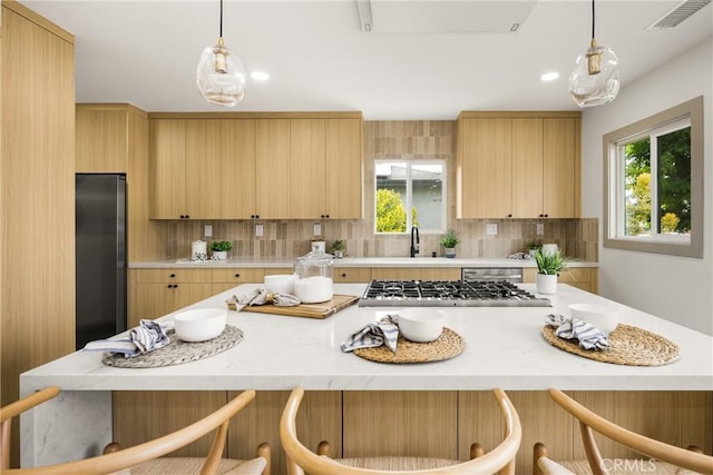 5161 E 27th St, Long Beach, CA 90815 - kitchen with appliances with stainless steel finishes, light brown cabinetry, a breakfast bar area, and recessed lighting