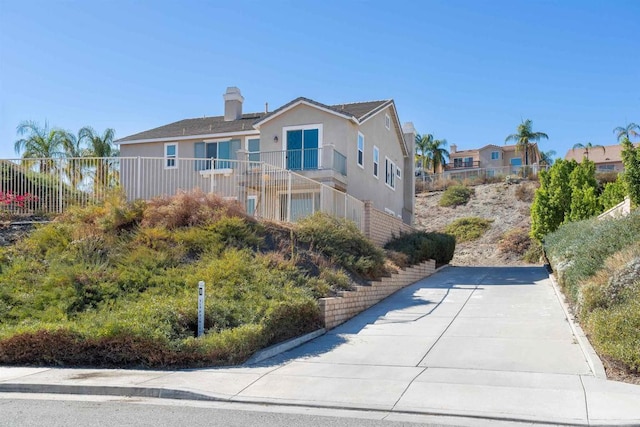 18 Via Palmieki Ct, Lake Elsinore, CA 92532 - view of property exterior featuring stucco siding and a chimney