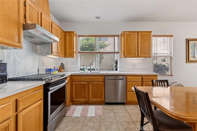 69 Serena Way, Stanton, CA 90680 - kitchen featuring appliances with stainless steel finishes, a sink, exhaust hood, light countertops, and brown cabinetry