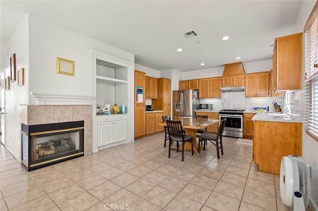 69 Serena Way, Stanton, CA 90680 - kitchen with appliances with stainless steel finishes, recessed lighting, light tile patterned floors, light countertops, and a tiled fireplace
