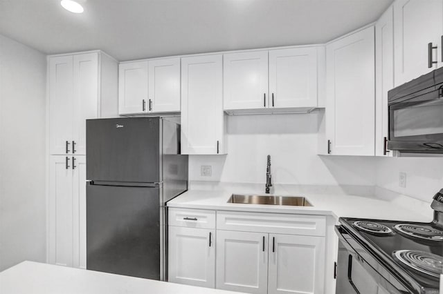 6362 Rancho Mission Rd Unit 712, San Diego, CA 92108 - kitchen featuring freestanding refrigerator, a sink, black microwave, range with electric cooktop, and white cabinetry