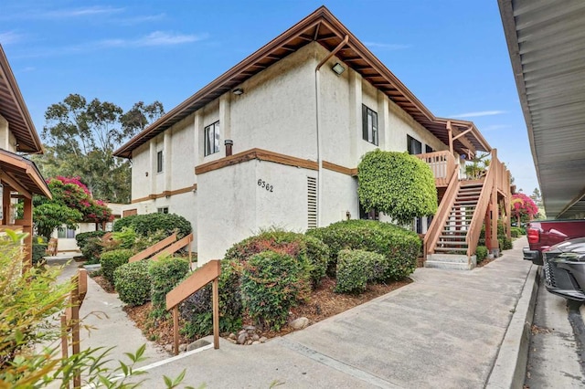6362 Rancho Mission Rd Unit 712, San Diego, CA 92108 - view of side of home with stucco siding, stairway, and a deck