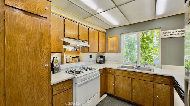 8601 Burnet Ave Unit D, North Hills, CA 91343 - kitchen with under cabinet range hood, white appliances, a sink, brown cabinets, and decorative backsplash
