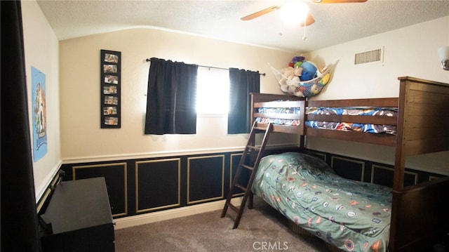 6384 E Lowe Ave, Fresno, CA 93727 - carpeted bedroom featuring a textured ceiling, lofted ceiling, a wainscoted wall, and ceiling fan