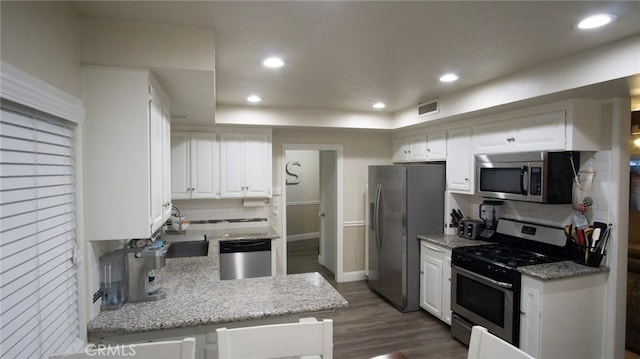 6384 E Lowe Ave, Fresno, CA 93727 - kitchen featuring appliances with stainless steel finishes, tasteful backsplash, white cabinetry, dark wood finished floors, and recessed lighting