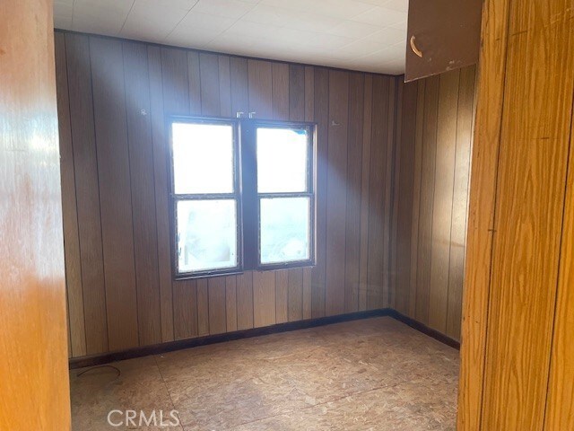 100 Aliso St, Needles, CA 92363 - unfurnished room featuring wooden walls