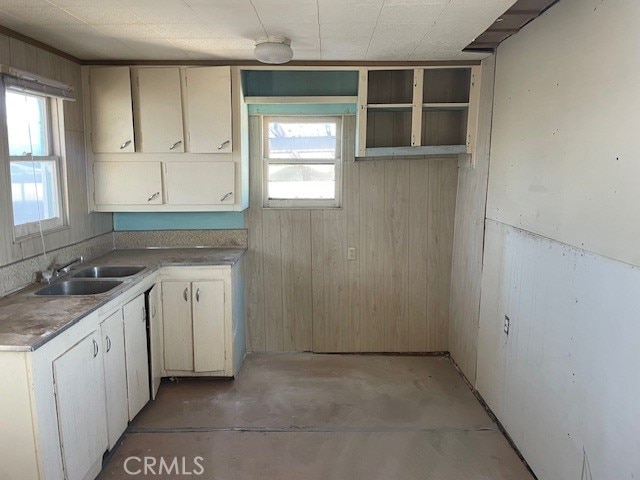 100 Aliso St, Needles, CA 92363 - kitchen featuring a sink, wooden walls, and unfinished concrete floors