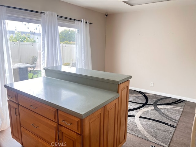 3751 Ketch Ave Unit D, Oxnard, CA 93035 - kitchen featuring a kitchen island, brown cabinets, light wood finished floors, and baseboards