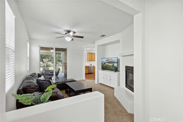 33184 Puffin St, Temecula, CA 92592 - living area with a glass covered fireplace, ceiling fan, and light carpet