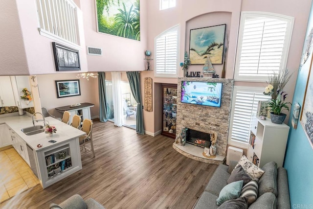 4610 Los Alamos Way Unit C, Oceanside, CA 92057 - living room with a chandelier, a fireplace, a high ceiling, and light wood-style flooring
