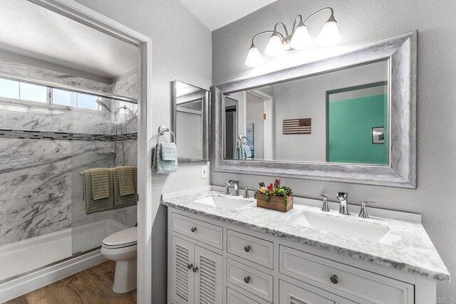 4610 Los Alamos Way Unit C, Oceanside, CA 92057 - bathroom featuring a stall shower, toilet, double vanity, and wood finished floors
