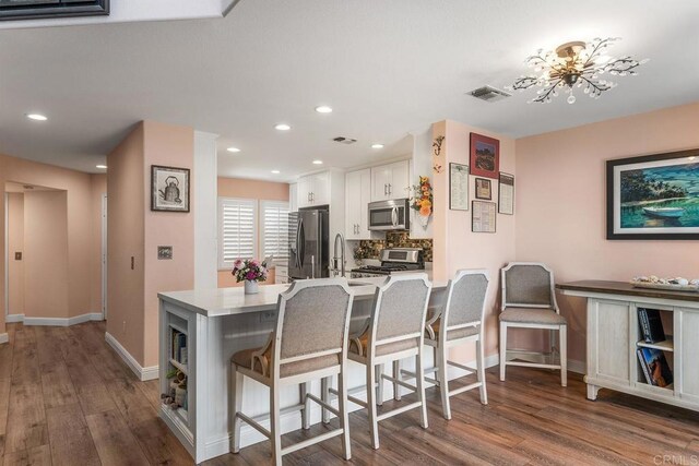 4610 Los Alamos Way Unit C, Oceanside, CA 92057 - kitchen featuring stainless steel microwave, fridge with ice dispenser, range, white cabinets, and wood finished floors