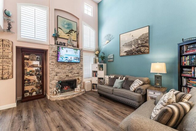 4610 Los Alamos Way Unit C, Oceanside, CA 92057 - living area featuring wood finished floors, a towering ceiling, a fireplace, and baseboards