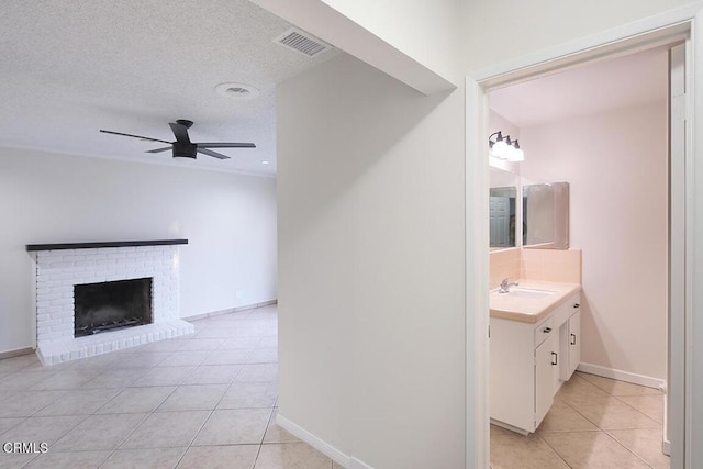 139 Spanner St, Monrovia, CA 91016 - bathroom with tile patterned floors, vanity, ceiling fan, a fireplace, and a textured ceiling