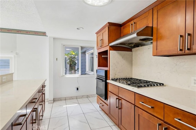 344 E Reed St, Covina, CA 91723 - kitchen with oven, under cabinet range hood, stainless steel gas stovetop, light countertops, and brown cabinets