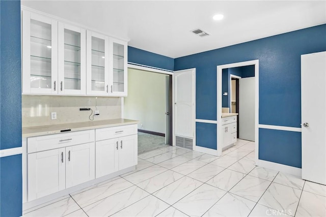 344 E Reed St, Covina, CA 91723 - kitchen featuring white cabinets, light countertops, glass insert cabinets, and light marble finish floors