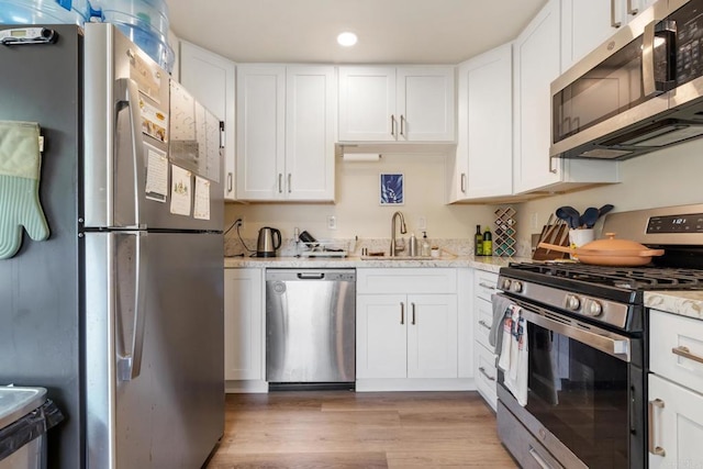 102733 3rd St, Encinitas, CA 92024 - kitchen with appliances with stainless steel finishes, a sink, white cabinets, light wood-style floors, and recessed lighting