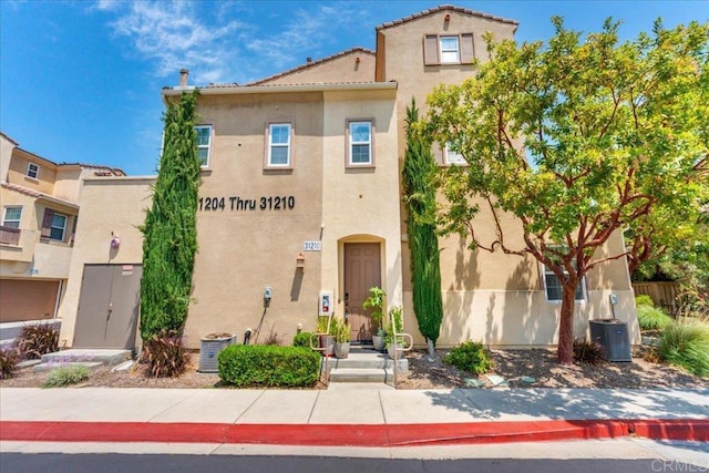 31210 Strawberry Tree Ln Unit 52, Temecula, CA 92592 - view of front facade with stucco siding, central air condition unit, and a tiled roof
