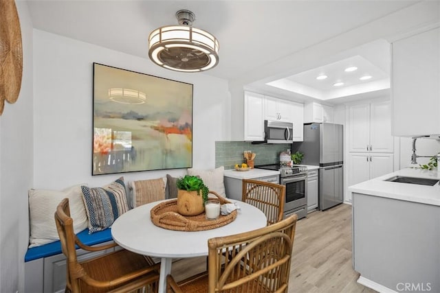 25611 Quail Run Unit 18, Dana Point, CA 92629 - dining area with light wood-type flooring, recessed lighting, and a tray ceiling