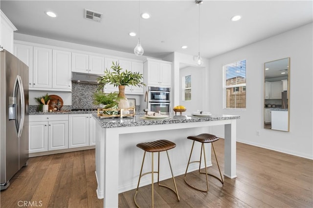 333 Calle Elegante, Lake Forest, CA 92630 - kitchen with appliances with stainless steel finishes, white cabinetry, wood finished floors, stone counters, and recessed lighting
