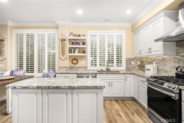 38 Tessera Ave, Lake Forest, CA 92610 - kitchen with wall chimney exhaust hood, a sink, stainless steel range with gas stovetop, crown molding, and white cabinetry