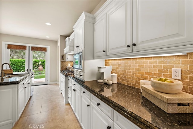 21 Corte Lomas Verdes, San Clemente, CA 92673 - kitchen with a sink, decorative backsplash, white cabinets, dark stone countertops, and stainless steel microwave