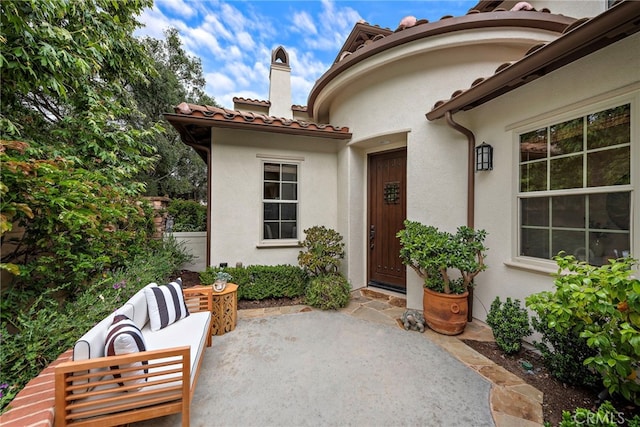 21 Corte Lomas Verdes, San Clemente, CA 92673 - doorway to property with a patio, a chimney, stucco siding, an outdoor living space, and a tiled roof
