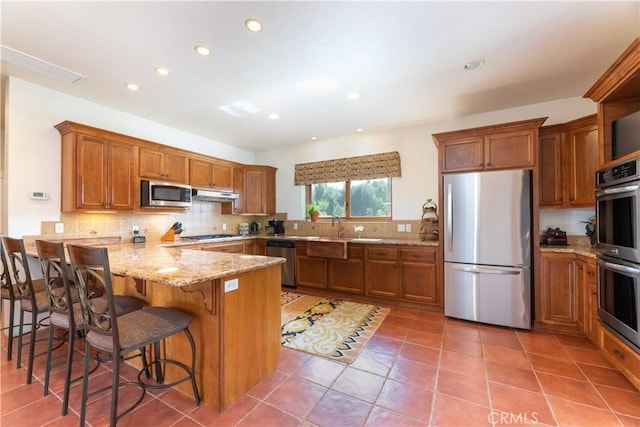 1615 Halsey St, Redlands, CA 92373 - kitchen with stainless steel appliances, brown cabinets, a peninsula, decorative backsplash, and recessed lighting
