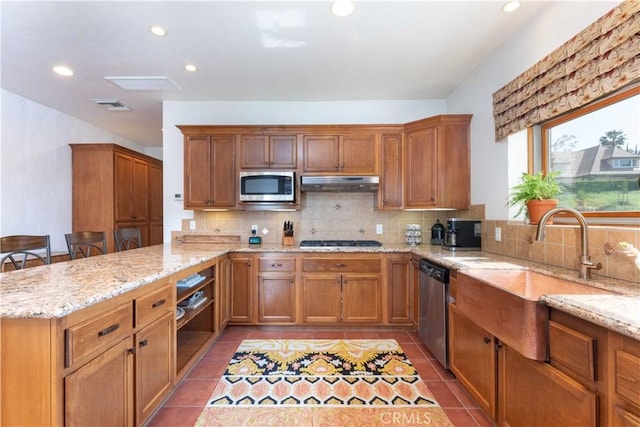 1615 Halsey St, Redlands, CA 92373 - kitchen featuring appliances with stainless steel finishes, under cabinet range hood, decorative backsplash, a peninsula, and brown cabinetry