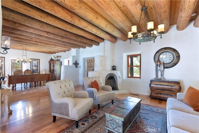 1615 Halsey St, Redlands, CA 92373 - living room with a chandelier, a wooden ceiling with exposed beams, wood finished floors, and a fireplace with raised hearth