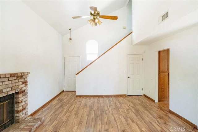 3117 Andre Ln, Turlock, CA 95382 - unfurnished living room with high vaulted ceiling, light wood finished floors, a brick fireplace, stairway, and ceiling fan