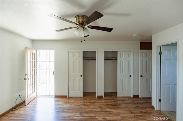 3117 Andre Ln, Turlock, CA 95382 - unfurnished bedroom featuring wood finished floors, two closets, a ceiling fan, and a textured ceiling