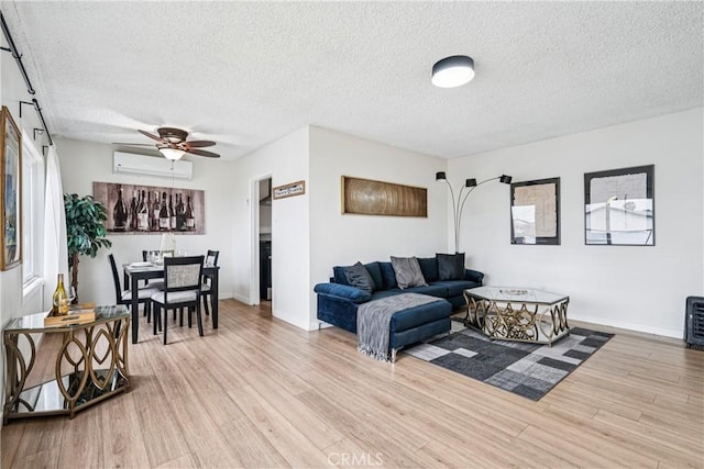509 N Hillford Ave, Compton, CA 90220 - living room with a wall unit AC, wood finished floors, a textured ceiling, baseboards, and a ceiling fan