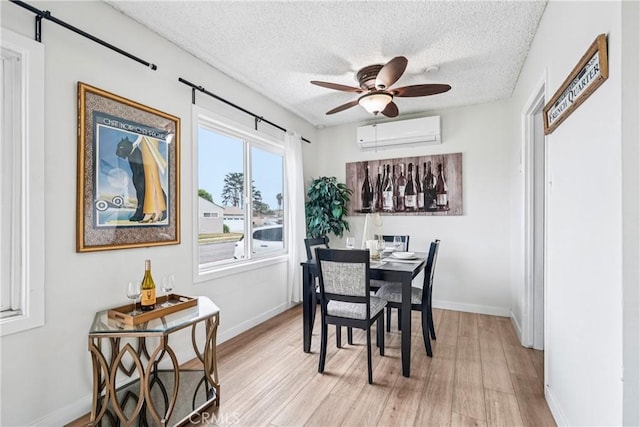 509 N Hillford Ave, Compton, CA 90220 - dining room with a wall unit AC, light wood-type flooring, a barn door, a textured ceiling, and ceiling fan