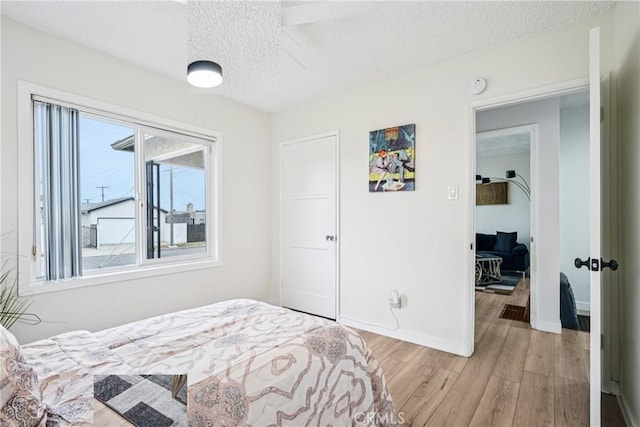 509 N Hillford Ave, Compton, CA 90220 - bedroom featuring a textured ceiling, light wood finished floors, and baseboards