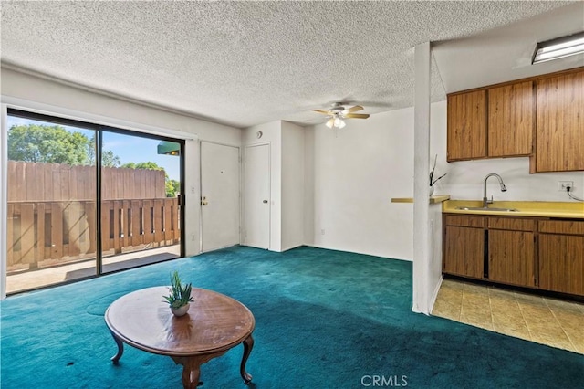 17900 Sherman Way Unit 416, Reseda, CA 91335 - unfurnished living room with a sink, light colored carpet, ceiling fan, and a textured ceiling